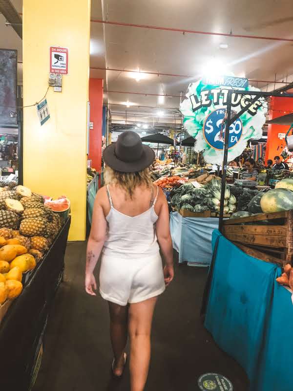 girl walking through busy cairns fruit market