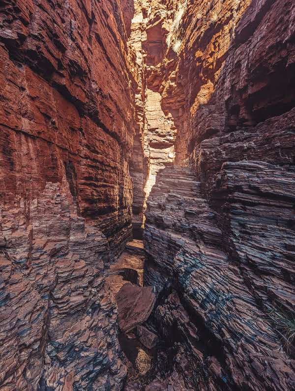 red sandstone rocks creating a narrow gap through weano gorge into handrail swimming pool