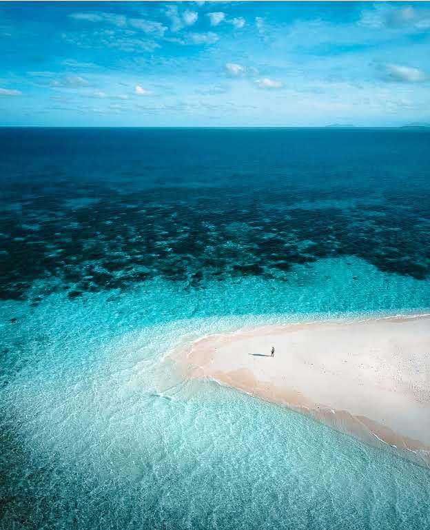 sandbar surrounded by crystal blue water at the cheap holiday destination cairns