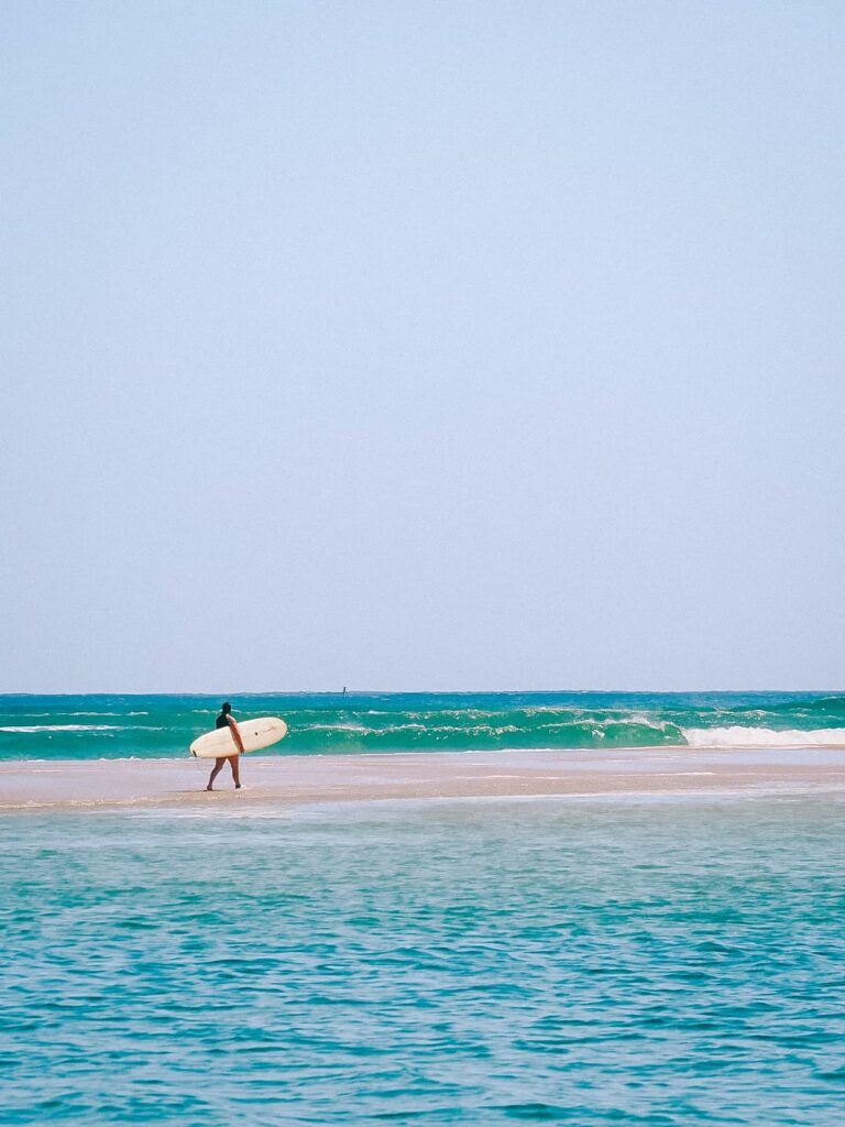 Surfer walking along the beach