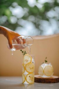 delicious lemonade being poured into a glass lined with lemon slices