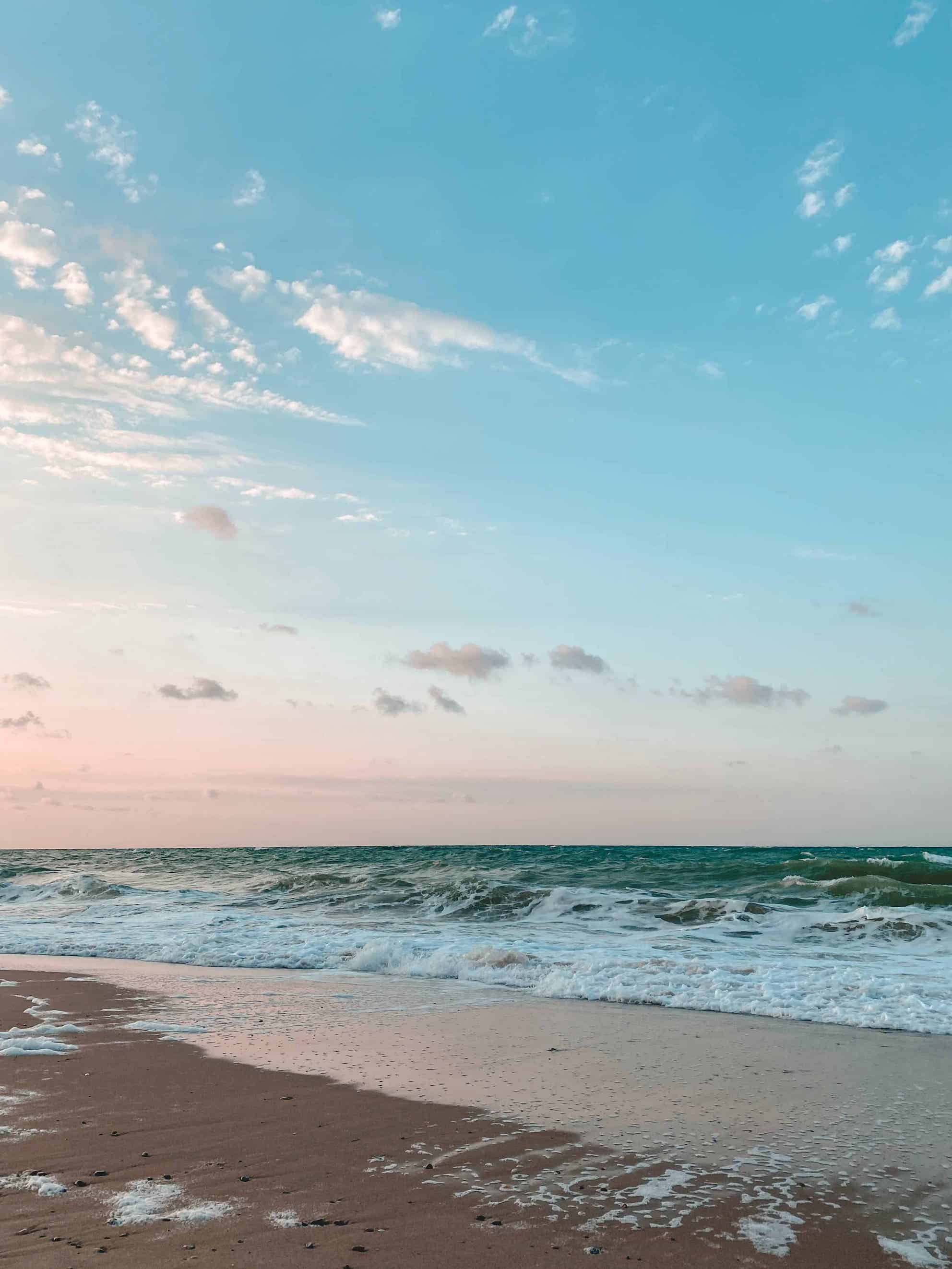 Australian beach. the sand is light yellow and the ocean is bright blue.