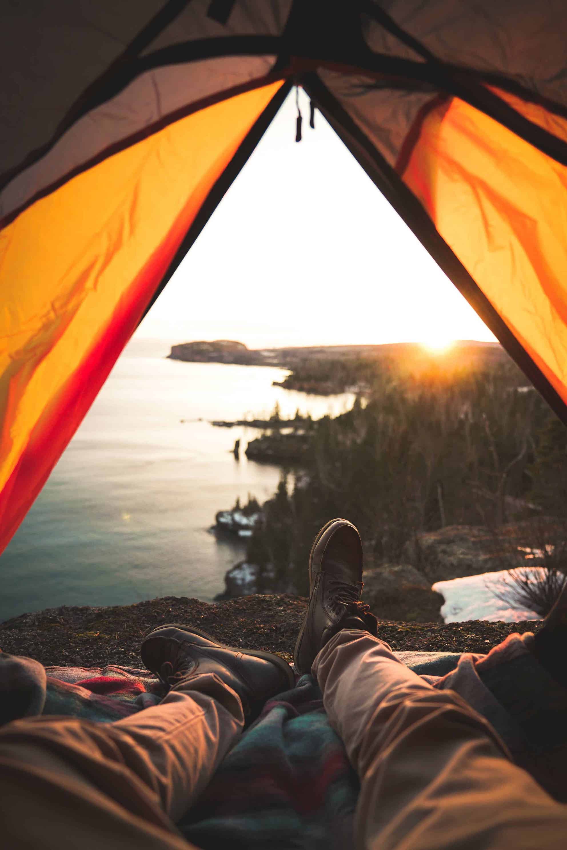 photo is taken through the entrance of the tent. the view is of the ocean. 