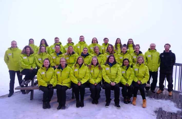 Me (Jade), working a ski season in Australia at Mount Hotham.
A dozen people wearing green staff ski a jackets are lined up for a staff photo.