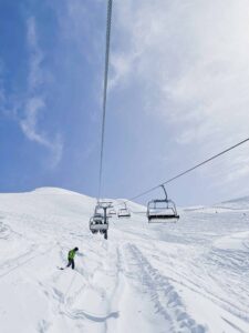 Chair lift running above one of my favourite ski runs that I found working a ski season at mount hotham. The sky is pale blue behind the chairlift