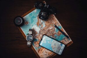 best apps for travelling around Australia displayed on a smart phone. the phone is sat on an old map on top of dark wooden table.